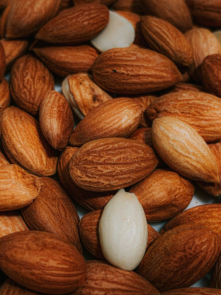 A detailed image showcasing a heap of raw and unpeeled almonds, perfect for healthy snacking.